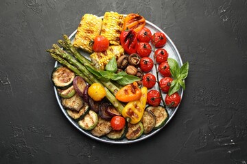 Delicious grilled vegetables on grey textured table, top view