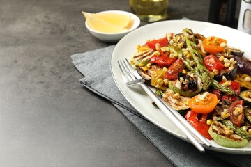 Delicious salad with grilled vegetables served on gray textured table, closeup. Space for text