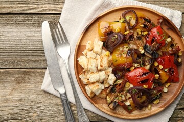 Delicious salad with grilled vegetables served on wooden table, flat lay
