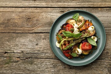 Delicious salad with grilled vegetables on wooden table, top view. Space for text