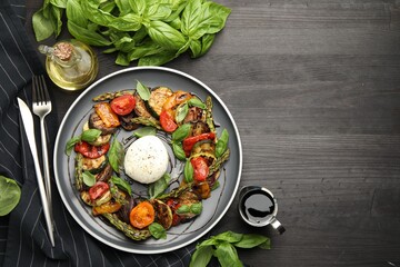 Tasty salad with grilled vegetables and mozzarella cheese served on black wooden table, flat lay. Space for text