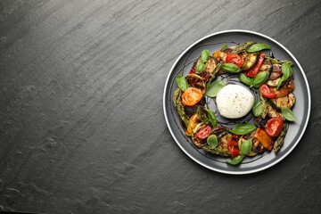 Tasty salad with grilled vegetables and mozzarella cheese on grey textured table, top view. Space for text