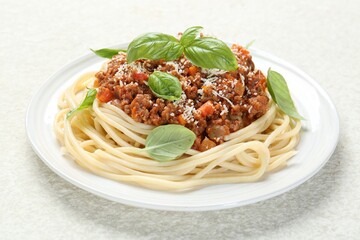 Tasty pasta bolognese with basil on white table, closeup