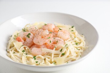 Delicious pasta with shrimps and cheese on white table, closeup