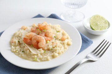 Delicious risotto with shrimps and cheese on white table, closeup