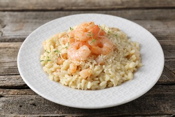 Delicious risotto with shrimps and cheese on wooden table, closeup