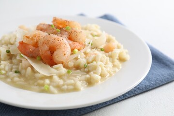 Delicious risotto with shrimps and cheese on white table, closeup