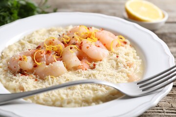 Delicious risotto with shrimps and cheese on wooden table, closeup