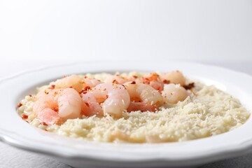 Delicious risotto with shrimps and cheese on table, closeup