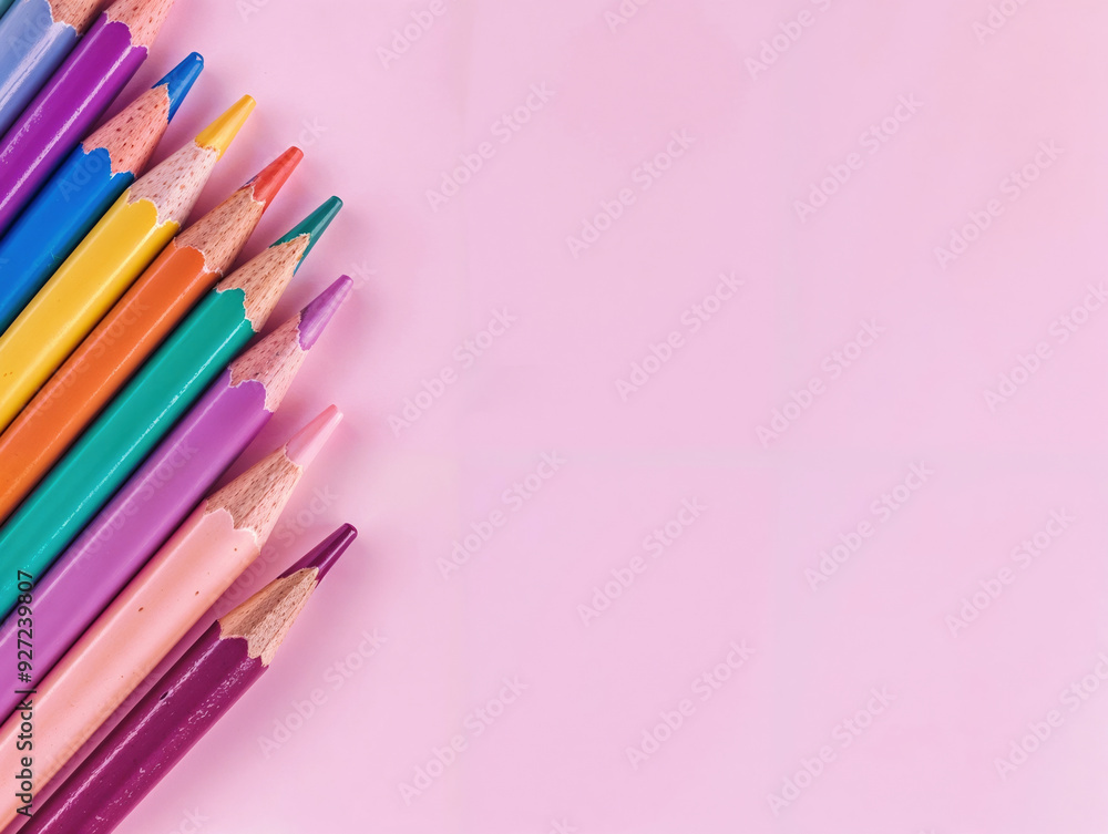 Poster row of colored pencils forming a diagonal line on a pink background with copy space