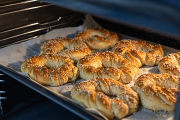 Freshly baked homemade bagels with poppy and sesame seeds. Process of baking dough.
