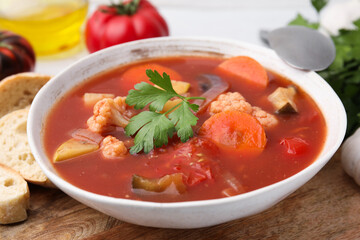 Delicious homemade stew in bowl and bread on table, closeup