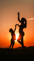 Fototapeta premium Silhouette of a mother and child dancing at sunset