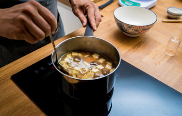 Chef at the kitchen preparing healthy quinoa bowl with avocado
