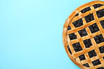 Tasty homemade pie with blueberries on light blue table, top view. Space for text