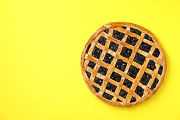Tasty homemade pie with blueberries on yellow table, top view. Space for text