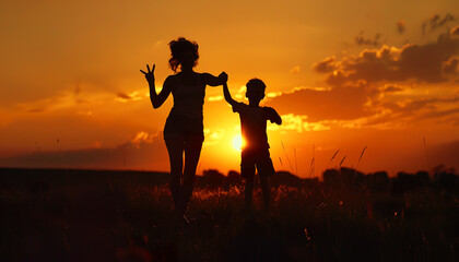 Fototapeta premium Silhouettes of a Mother and Child Against a Sunset Sky
