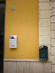 Vertical Close-Up of Two Mailboxes on a Yellow Wall in Olbia’s Historic Center