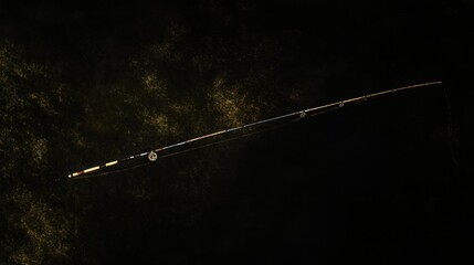 A fishing rod lays on a dark background.
