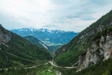 Obraz premium Scenic aerial view of majestic alpine landscape with snow-capped mountain ridges of Schladminger Tauern in Ramsau am Dachstein, Styria, Austria. Hiking trail through alpine greenery in Austrian Alps