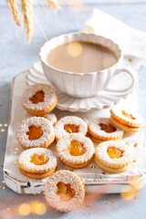 Christmas shortbread cookies with orange jam and a cup of coffee, selective focus