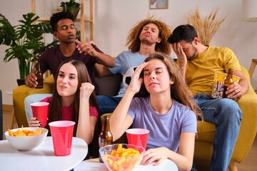 Group of devastated sports fans watching their football team losing on TV at home.