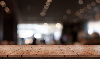 Empty wooden table top with lights bokeh on blur restaurant background