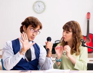 Young woman during music lesson with male teacher