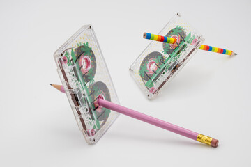 Old music magnetic cassette and wooden pencil on white background