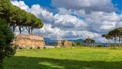 Obraz premium Ancient roman aqueduct ruins in Rome public park with beautiful clouds