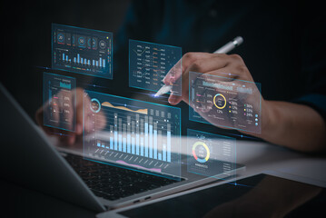 Hands working on financial data analysis on a laptop, digital charts and graphs KPI key performance...