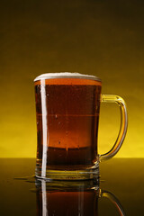 Glass of beer with froth on dark table, closeup
