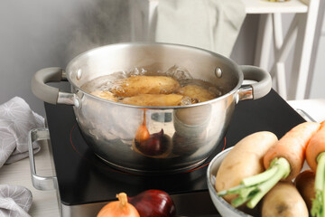 Boiling potatoes in metal pot on stove