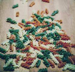 Raw colorful sryral pasta, scattered by table