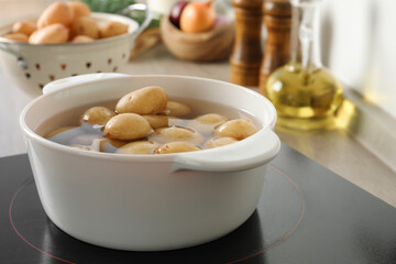 Boiling potatoes in pot on stove in kitchen