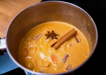 Chef at the kitchen preparing massaman curry with sweet potato and many spices