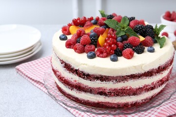 Tasty sponge cake with different fruits and mint on light grey table