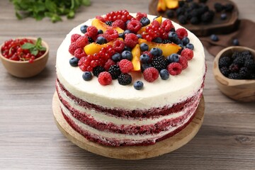 Tasty sponge cake with different fruits on wooden table