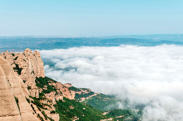 View from Sant Jeroni peak of Montserrat mountains and clouds over green landscape