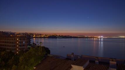 Obraz premium Panoramic image of the rising sun over the sea on a coast with buildings