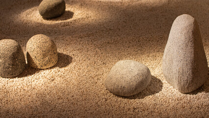 Composition of granite stones in a minimalist Japanese indoor garden with white gravel soil.