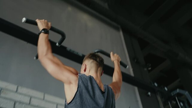 A man engaging in pull-ups at a gym, focusing on strength training and fitness. The image depicts dedication, upper body workout, and healthy lifestyle. Man Performing Pull-Ups in Gym