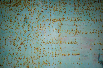 Old grungy green metal wall with rust specks