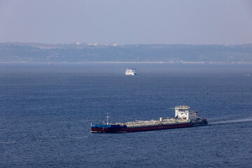 Navigation on the Volga River. A tanker barge in the foreground, a cruise ship in the background.