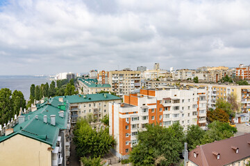 View of the city and the Volga River embankment from a height. A summer day, clouds in the sky. The city of Saratov, Russia