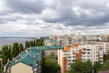 View of the city and the Volga River embankment from a height. A summer day, clouds in the sky. The city of Saratov, Russia