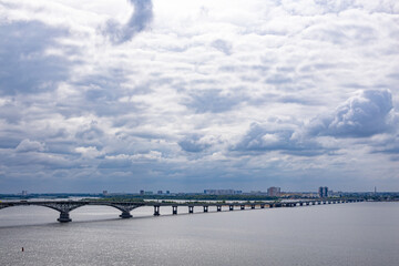 A road arch bridge over the Volga River between the cities of Saratov and Engels, Russia. Summer landscape. Clouds in the sky.