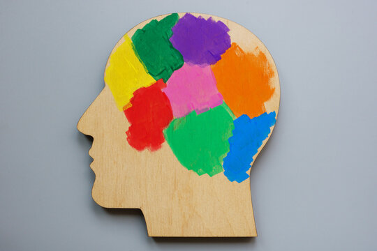 Model head painted with colorful paints, symbolizing neurodiversity and individual differences.