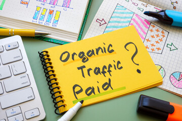 Notebook with a choice between paid and organic traffic, symbolizing marketing strategy.