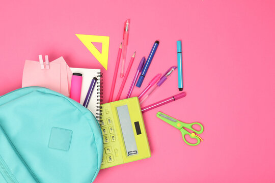 Backpack and different school supplies on pink background, flat lay. Space for text